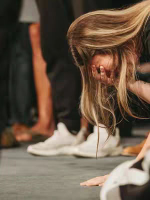The cover image features a woman with long blonde hair, partially obscuring her face. She appears to be in a public space, with other people's legs and feet visible in the background. Her hands are covering her face, possibly in a gesture of grief or distress.