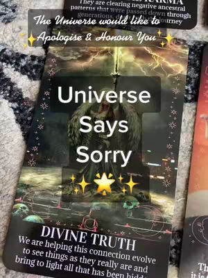 An artistic shot featuring a tarot card laid on a textured, patterned surface. The card has a dark background illustrating a stormy sky with lightning and a central figure with outstretched wings. Bold, white text overlays the image, with a main title and supplementary phrases. Decorative elements like stars and the phrase "DIVINE TRUTH" are also present. The overall tone is mystical and related to spiritual guidance.