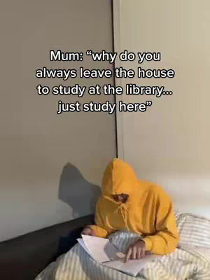 The image shows a person wearing a yellow hoodie sitting on a bed and studying with a white paper and pen. Text overlay shows the question 'Mum: "why do you always leave the house to study at the library... just study here"'. The background is a plain wall, and the overall composition is casual and relatable.