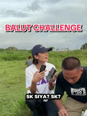The cover image shows two people standing in a grassy field, with a woman in the foreground holding phones and talking. The background includes a few trees and a cloudy sky. Text overlays are added to the image.