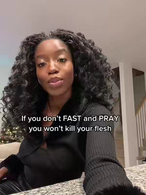 A woman with dark hair and a black top is positioned in front of a neutral-toned background. Text overlayed in the bottom left corner states: 'If you don't FAST and PRAY you won't kill your flesh'. The woman is looking straight at the viewer. Background shows a couch and a staircase.
