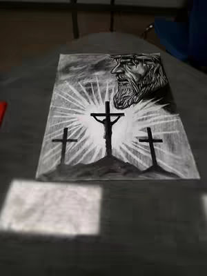 The image depicts a charcoal drawing centered on a religious theme. In the foreground are three crosses set on a hill. Behind them is a bright light emanating from a figure, possibly Jesus, who is depicted in profile with a crown of thorns. The art style appears to be detailed, with significant contrast. The piece is set against a plain background.