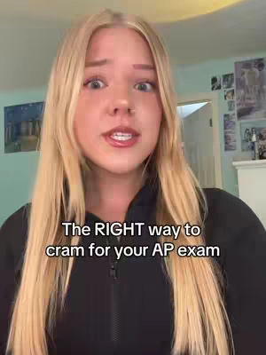 A young woman with long blonde hair is centered in a vertical video frame, speaking directly to the camera. Text is overlaid on the lower section of the video. The background is a domestic setting, including wall decorations.