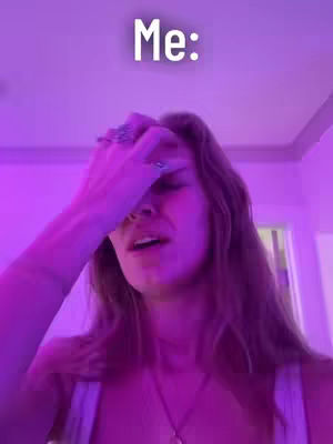 A woman with long brown hair is seen in a room lit with pink light. She is holding her hand up to her forehead with a look of distress or exasperation. The text "Me:" is at the top of the image.