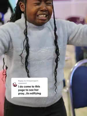 A young girl with long, dark braids is shown crying with her arms slightly raised. She is center focus, with a focused expression. A comment overlay appears in the bottom-left corner.