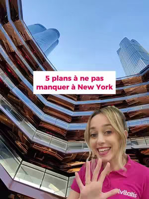 A woman is centered in the foreground, smiling and holding up five fingers. Behind her is a complex, modern architectural structure with reflective, geometric surfaces. Above, text on a pink background reads "5 plans à ne pas manquer à New York". The background features a clear light blue sky.