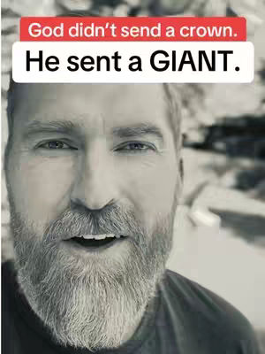 A close-up shot in black and white of a man's face. He has a full beard and the text overlay states, 'God didn't send a crown. He sent a GIANT.'