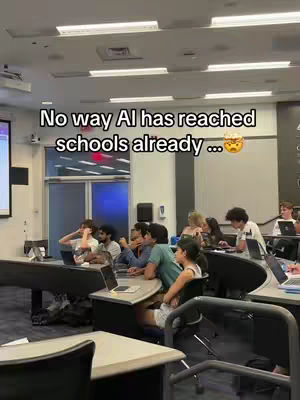 The image shows a classroom setting with multiple students seated at desks, each with a laptop. The lighting indicates it's likely daytime, with bright overhead fixtures. The text overlay reads, 'No way AI has reached schools already ...' The layout shows desks arranged in rows creating a dynamic composition.