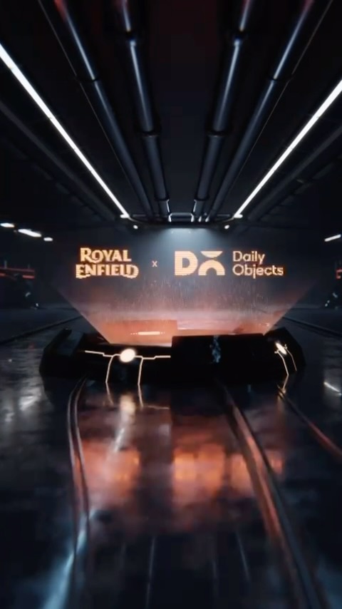 A futuristic, tunnel-like view with a dark and sleek aesthetic. The scene emphasizes depth and perspective, guiding the viewer's eye towards a central illuminated platform. The Royal Enfield and DailyObjects logos are prominently displayed with a holographic effect.
