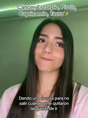A young woman with long dark hair is centered in the frame, looking slightly to the side with a subtle smile. Behind her, a muted green background creates a soft contrast, with a string of small lights visible along the top. The woman wears a light pink shirt and a delicate necklace, adding to the image's gentle and approachable feel. Text overlays are present at the top stating zodiac signs and the bottom describing actions.