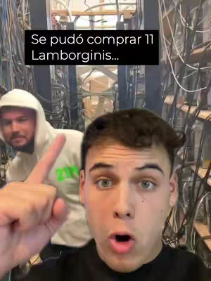 A selfie-style video featuring a young man in the foreground with an open mouth, looking surprised at the camera. Behind him, slightly blurred but visible, is another man wearing a hoodie, also looking towards the camera. A text overlay in a black rectangle is placed at the top, and the setting seems to be some sort of server room with lots of wires.