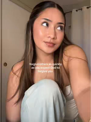 A young woman with long brown hair sits in a room, looking up attentively. The image has soft lighting. Text overlay on the image, which reads 'forgive others as quickly as you expect God to forgive you.'