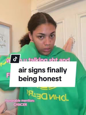 A young woman with a serious expression is the main focus, wearing a green hoodie. A white overlay box with black text states, 'air signs finally being honest.' A small honorable mention reads CANCER in white text on a pink background. The room has plain cream walls and a door frame.