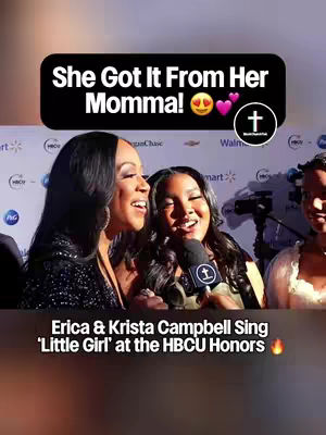 The image captures two women smiling and singing into a microphone. Above them is a black box with white text that states, 'She Got It From Her Momma!'. Below, there's text that says "Erica & Krista Campbell Sing 'Little Girl' at the HBCU Honors". The background is a blue carpet with patterns and logos, a microphone is near the women. The image has a warm, celebratory vibe.