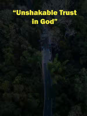 An overhead shot of a road winding through a forest. Text overlayed at the top reads "Unshakable Trust in God" in a yellow font.
