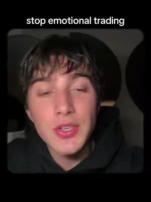 A close-up shot of a young man with dark hair, wearing a black hoodie, looking directly at the camera. Text overlay at the top reads 'stop emotional trading.' The background is out of focus and dark.