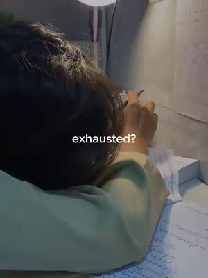 The cover image shows a person studying late at night, with their head resting on a desk covered in papers. A desk lamp illuminates the scene, casting shadows. The person’s hair obscures their face, and the text 'exhausted?' is overlaid on the image, adding a relatable feel to the image.