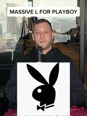 A man is holding a microphone, with the Playboy logo on a digital display over his torso and overlay text that says "MASSIVE L FOR PLAYBOY". The background has a cityscape and interior office elements.