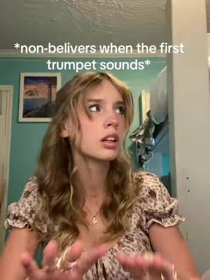 A young woman with long wavy hair and a floral top is looking slightly upward with a look of surprise and concern. Text is overlaid at the top, with a framed picture and wall visible near some of the woman's head. The background is teal, there are some ceiling decorations and the woman's hands are visible in the image with a number of rings.
