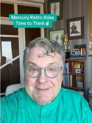 A selfie-style shot with the creator in the foreground against a cozy indoor background with a window and decorative elements. The creator is wearing glasses and a green shirt, and there is overlayed text in the upper left.