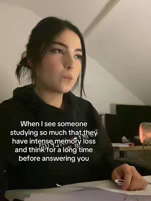 A young woman with dark hair, wearing a black hoodie, looks slightly upwards and to the left while holding a pen. Text overlaid on the image describes a relatable scenario about someone studying so much they have memory issues.