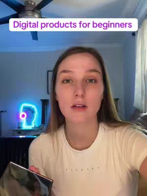 A woman looking at the camera, holding a phone. A text overlay at the top says "Digital products for beginners". The background shows a ceiling fan, a light blue wall with a neon light, a bed, and curtains.