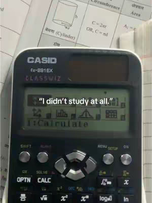 A close-up shot of a Casio calculator displaying the text "I didn't study at all." The calculator is set against a backdrop of what appears to be a math-related document, with some Hindi script is visible.