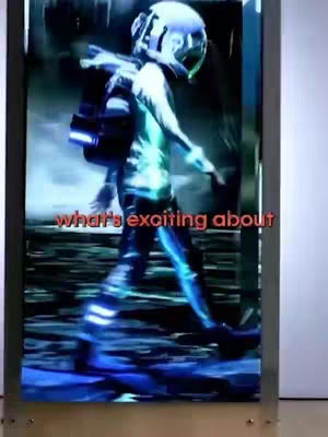The cover image shows a glowing figure walking in a futuristic setting, displayed on a large screen, with the words 'what's exciting about' overlaid in red text. The figure, seemingly wearing a helmet and futuristic gear, glows with blue and green light. The background is a blurred, dark environment. A metallic frame surrounds the screen. The overall composition is dynamic with a slightly distorted visual feel, suggesting movement and digital art.