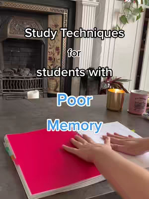 The cover image shows a close-up view of a table with a red notebook open on the left and a white notebook on the right. The background shows a fireplace and some decor. Text overlays state 'Study Techniques for students with Poor Memory' in a vertical format.