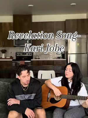 A cover image with a man and a woman sitting on a dark couch. The woman is holding a guitar, and the man is looking down. Text overlays at the top.