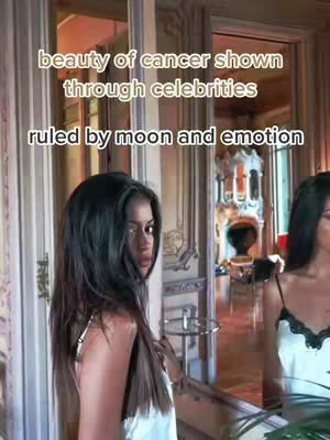 A woman with long dark hair stands in side profile in a well-lit room with a mirror. Text on the cover says "beauty of cancer shown through celebrities" and "ruled by moon and emotion".