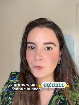 A woman with brown hair and a floral top is shown in a selfie-style shot. Text overlays appear at the bottom of the screen. The background is a soft, neutral color, and the woman is looking directly towards the camera.