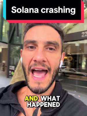 A man with a beard and dark hair stares at the camera. Text overlays include "Solana crashing" in a black bar at the top and "AND WHAT HAPPENED" in a yellow box towards the bottom. The man wears a black hoodie and white earbuds while standing on a street. Buildings and greenery are visible in the background.