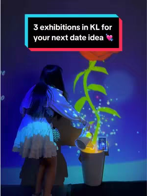 A young woman is standing in front of a projected image of a large flower emerging from a bucket. She is holding a watering can, and the background is a dark blue with scattered light effects. The image has a vibrant, colorful composition with the subject centered in the frame.