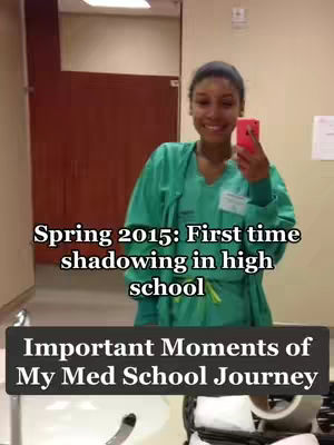 A woman in green medical scrubs takes a selfie in a well-lit bathroom. The image displays a mirror reflection. Text overlays indicate the setting and a title.