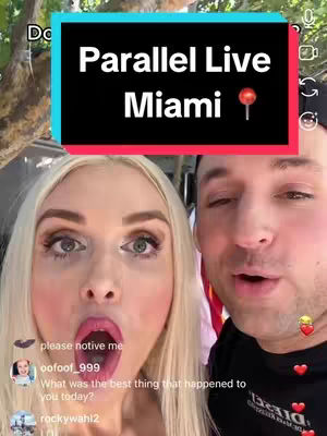 A selfie taken from a close-up angle, featuring two individuals: a woman with blonde hair and striking makeup, and a man. They are both partially visible, positioned side by side, the woman taking up more space in the frame emphasizing her facial features. The background appears blurred but suggests an outdoor setting. Overlay text in a frame announces 'Parallel Live Miami'. The frame is blue with the text in white, with a lollipop icon. Additional elements include social media interaction elements arranged around the duo.