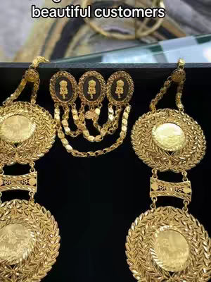 The cover image displays a close-up of exquisite gold jewelry, including a necklace and earrings. The jewelry is intricately designed with circular pendants and ornate details. The pieces are arranged against a dark backdrop, which accentuates the gold's luster and the fine craftsmanship. The upper part of the image has some text overlaying.