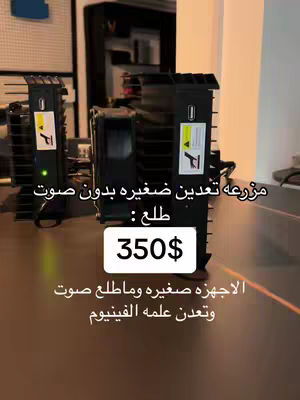 The image shows three black, boxy devices with fan-like structures prominently displayed on a light-brown surface. Text overlays indicate the devices are for cryptocurrency mining, specifying "without sound" and a price of $350. The composition focuses on the technical setup, utilizing a simple color palette and clear labeling for product presentation.