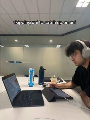 The cover image shows a person sitting at a desk with a laptop, tablet, and water bottle. The person is wearing headphones and appears to be focused on the screens in front of them. The words "skipping uni to catch up on uni" are the hook text. Objects like a water bottle and a juice box are in view.