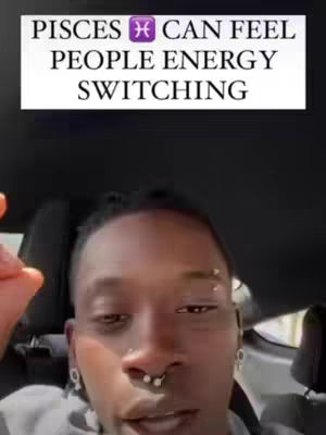 A selfie-style video with the creator in the foreground and text overlayed at the top. The creator is a dark-skinned male with facial piercings, in a car setting. The text overlay says, "PISCES can feel people energy switching". The background is blurred, but seems to be the interior of a vehicle.