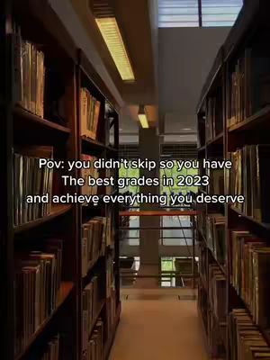 An interior shot of a library with bookshelves on both sides and a central pathway. The lighting is provided by overhead lights. Overlayed text provides motivational message.