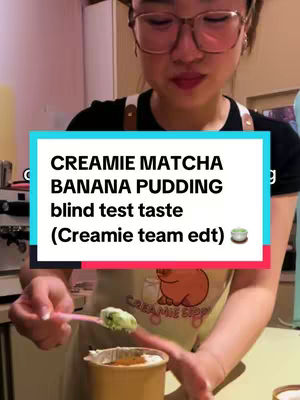 The cover image shows a woman in glasses preparing a matcha banana pudding. She is holding a pink spoon with a spoonful of the pudding, which has a green top layer. The pudding is in a small, gold-colored cup. A text overlay with a blue background provides information about the dessert.
