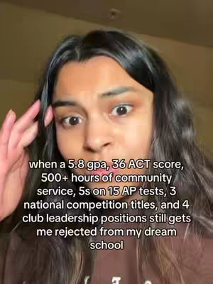 A close-up shot featuring a young woman with dark hair and brown attire. She is looking at the camera with wide eyes, and her hand is touching her head. Overlayed text details her academic achievements and rejection from her dream school.