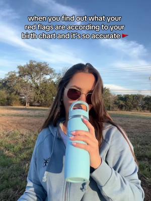 A woman in a blue hoodie and sunglasses drinks from a water bottle in front of a partly cloudy sky. Text overlay at the top.