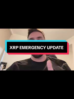 A man is centered in a vertical frame, with a dark background and minimalist setup. The man, lit by a front-facing light, is wearing a dark t-shirt. Above, a text overlay reads "XRP EMERGENCY UPDATE" in bold white font against a teal rectangle, which is bordered by a thin red line. The focus is on the man and the framed text, conveying the video's subject.