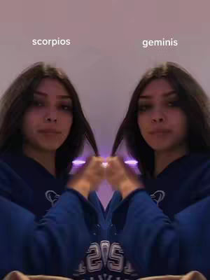 The cover image displays a symmetrical composition featuring a young woman on either side, mirroring each other. The background is a soft purple, with text labels identifying each side as "scorpios" and "geminis" respectively, positioned above the figures. The woman is the central focus of the image, dressed in a dark blue hoodie and dark hair. She holds her hair in front of her, creating a sense of symmetry and balance.