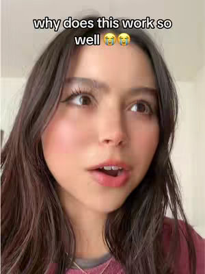 A close-up shot features a young woman with long, dark hair and a pink top. The top portion of the frame includes the text overlay, 'why does this work so well'. The woman gazes upward to the side with a slight open mouth, conveying a thoughtful yet animated expression. Her skin appears clear with light makeup.
