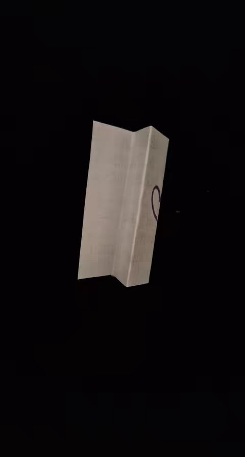 An image of a folded paper with a purple heart drawn on it, set against a black background.