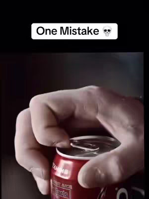 A close-up shot of a person's hand opening a red can with a white text overlay reading 'One Mistake'. The can is labeled with white text. The overall composition is dark, with a focus on the hand and the can.