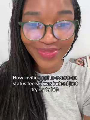 Close-up shot of a Black woman wearing glasses smiling. She has long, dark braids and is wearing a gray t-shirt. The background is a plain, light-colored wall. Text is overlaid at the bottom.